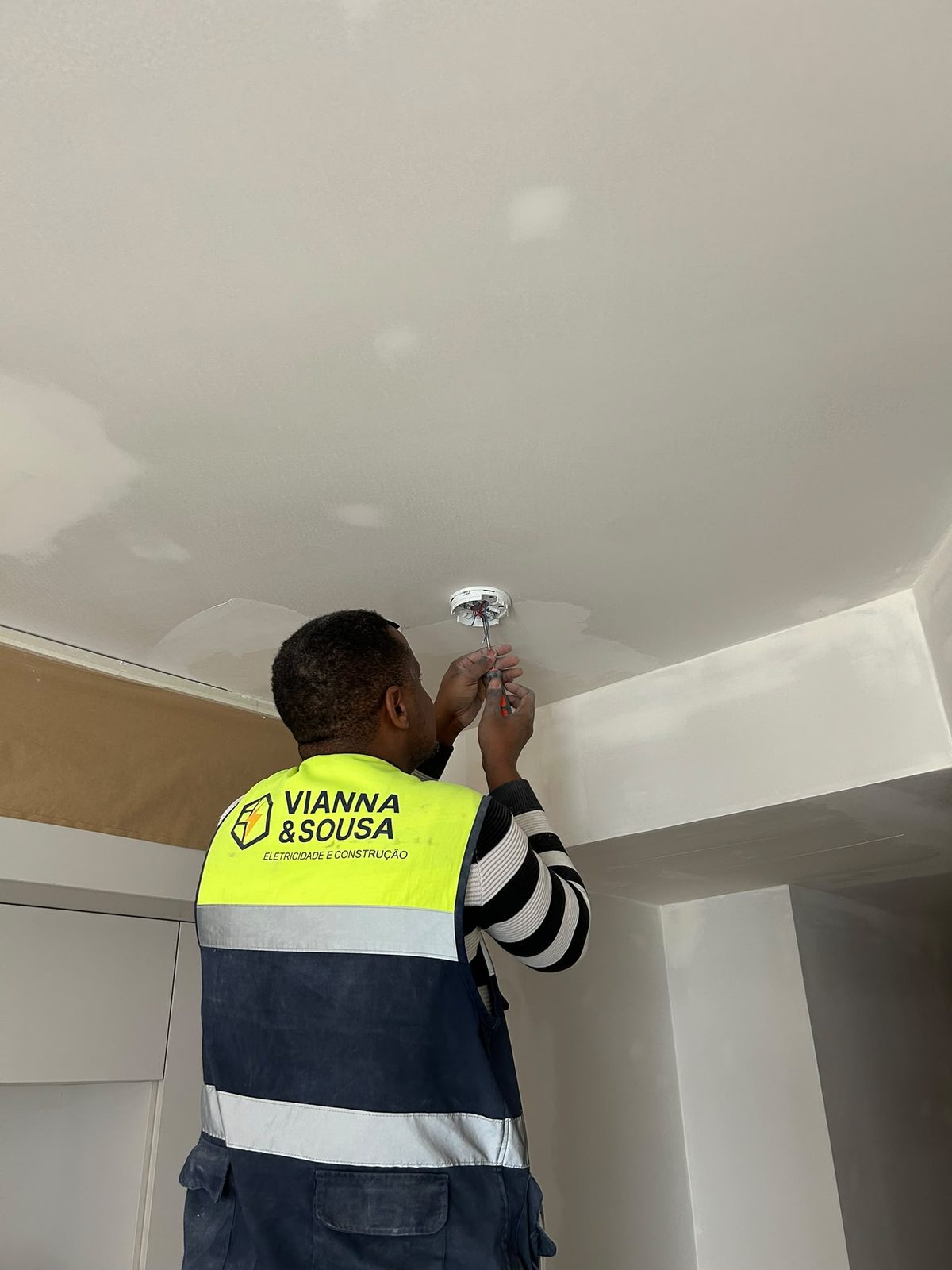 Eletricista da Vianna&Sousa a instalar iluminação em teto falso